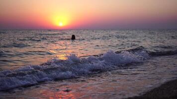 donna su spiaggia a tramonto. giovane viaggiatore a piedi di mare oceano spiaggia a d'oro tramonto luce. femmina turista godendo natura durante estate vacanza. lento movimento. vacanza ricreazione concetto. video