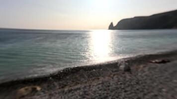 abstrait mer été océan le coucher du soleil la nature Contexte. petit vagues sur d'or l'eau surface dans mouvement brouiller avec d'or bokeh lumières de Soleil. vacances, vacances et des loisirs. temps et climat changement video