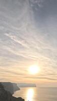 Timelapse fluffy Cirrus clouds moving in sky over calm sea. Abstract aerial nature summer ocean sunset, sea and sky view. Vacation, travel, holiday concept. Weather and Climate Change. Vertical video