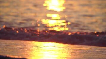 klein zee Golf, wazig zacht schuimend golven het wassen gouden zanderig strand Aan zonsondergang. oceaan golven Aan zanderig strand. niemand. vakantie recreatie concept. abstract nautische zomer oceaan zonsondergang natuur achtergrond. video