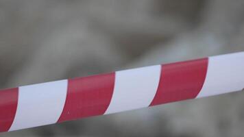 rood en wit waarschuwing plakband swinging in de wind. bescherming teken. niet doen kruis de lijn. rood wit voorzichtigheid plakband pool hekwerk is beschermt voor Nee binnenkomst. backdrop zonder mensen, leeg straat. video