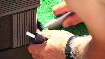 Man Cuting Artificial Grass carpet with knife. Artificial turf. Close up on hands. video