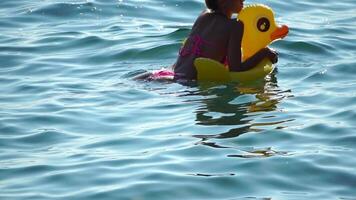 Sommer- Ferien Frau schwimmt auf ein aufblasbar Krapfen Matratze, ein Wasser Spielzeug schwimmen Ring. positiv glücklich Frau entspannend und genießen Familie Sommer- Reise Ferien Ferien auf das Meer. schleppend Bewegung video