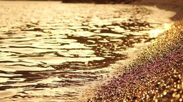 abstrakt Meer Sommer- Ozean Sonnenuntergang Natur Hintergrund. klein Wellen auf golden Wasser Oberfläche im Bewegung verwischen mit golden Bokeh Beleuchtung von Sonne. Urlaub, Ferien und Freizeit Konzept. niemand schleppend Bewegung video