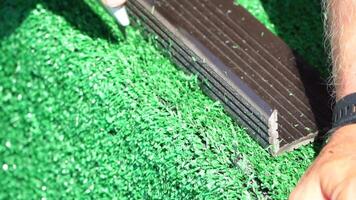 Man Cuting Artificial Grass carpet with knife. Artificial turf. Close up on hands. video