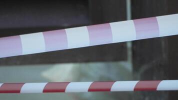 Red and white warning tape swinging in the wind. Protection sign. Don't cross the line. Red White caution tape pole fencing is protects for No entry. Backdrop without people, empty street. video