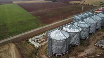 Grain elevator. Metal grain elevator in agricultural zone. Agriculture storage for harvest. Grain elevators on green nature background. Exterior of agricultural factory. Nobody. video