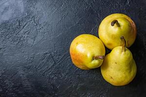 Fresco Fruta en oscuro antecedentes. composición de Tres peras. foto