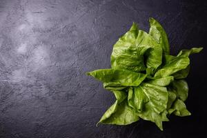 Chard leaves on a very dark colored table. Healthy food concept. photo