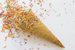 Ice cream in a waffle cone covered with bright sprinkling close-up photo