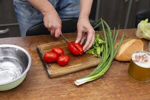 picar el verde cebollas y Tomates y sitio ellos en un bol. preparar el ensalada. foto