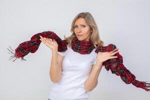 A beautiful adult woman waves a checkered warm scarf. photo