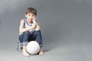 un niño con un fútbol pelota. el chico Sueños de convirtiéndose un fútbol americano jugador foto