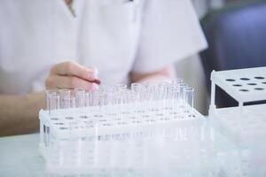 Hands of the doctor and glass test tubes. Medical containers for analysis on the background of hands photo