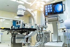 Operating theater with working equipment, lights and computers ready for surgeons. Medical devices, Interior hospital design concept. photo