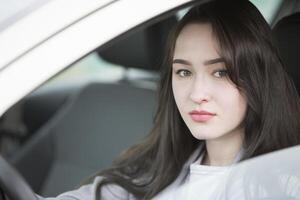 Young girl in the car. Beautiful woman driving photo