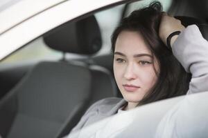 Young girl in the car. Beautiful woman driving photo