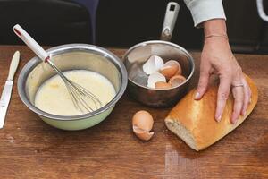 In a bowl there is a mixture for making an omelet and on the shells for eggs and a loaf. Prepare breakfast. photo