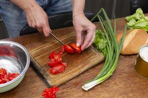 Chop the green onions and tomatoes and place them in a bowl. Prepare the salad. photo