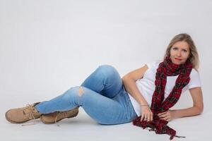 adulto hermosa esbelto mujer en pantalones y botas posando mientras acostado en el estudio. foto