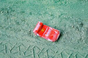 red cigarette packs thrown away haphazardly, Indonesia, 16 December 2023. photo