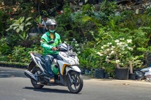 un en línea motocicleta Taxi o gojek conductor quien paseos su moto, Indonesia, 2 noviembre 2023. foto