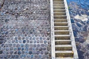 a concrete staircase in the mountains with stone walls photo