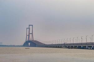 landscape of the Suramadu Bridge which stretches over the Madura Strait connecting the islands of Java and Madura Island photo