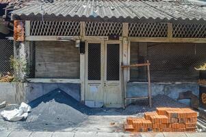 un antiguo casa siendo reparado con edificio materiales en el frente. foto