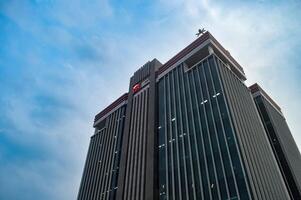 office building belonging to the Indonesian financial services authority OJK with a cloudy blue sky in the background, indonesia, 17 November 2023. photo