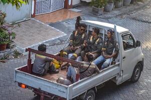 a group of project workers riding in a pick-up truck when they got home from work, Indonesia, 19 October 2023. photo