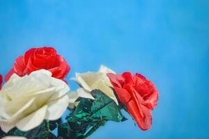 plastic flower bouquets for decoration on a plain blue wall background photo