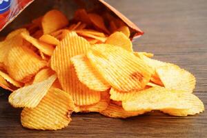 Potato chips in open bag, delicious BBQ seasoning spicy for crips, thin slice deep fried snack fast food. photo