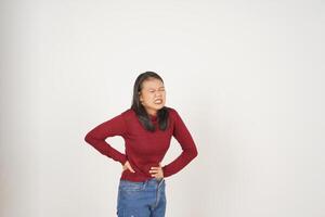 joven asiático mujer en rojo camiseta sufrimiento Dolor de estómago, dolor en estómago aislado en blanco antecedentes foto