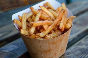 AI generated Crispy golden french fries in paper cone photo