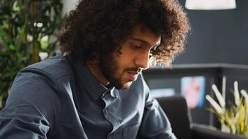 Company analyst searches for solutions to develop small business and increase profit, working on smartphone in open space office. Focused entrepreneur trying to solve task and startup issues. photo
