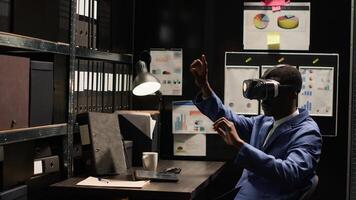 African American private detective investigates a suspicious case, using advanced technology and expert skills to gather clues and evidence. Policeman utilizing vr glasses to review criminal records. photo