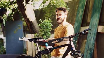 Side-view portrait of caucasian male exploring toolbox in home yard for bike maintenance. Dedicated young man with professional toolkit in hands for repairing and servicing bicycle. photo