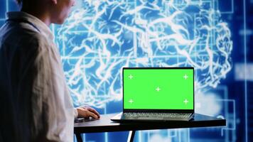 Proficient worker using green screen laptop to implement artificial intelligence parallel processing. Tech support man works on chroma key device enabling AI systems to do machine learning inference photo