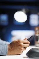 Worker delivers messages via text using app for smartphone, operating from home and following webinar course. Contractor using networking sites while attending online educational lesson. Close up. photo