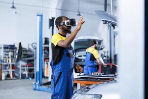 africano americano ingeniero en auto reparar tienda utilizando virtual realidad a visualizar coche batería en orden a reparar él. experto garaje trabajador vistiendo futurista vr auriculares mientras trabajando en roto vehículo foto