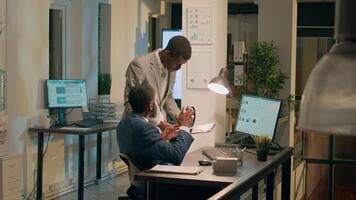 Manager annoyed by unattentive employee listening to music at work, upset about project mistakes he did. Management executive displeased by worker lack of focus in office during nightshift photo