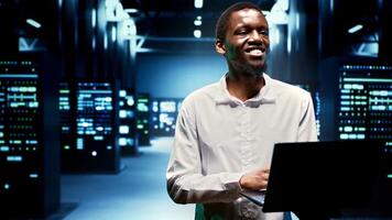 Happy engineer walking between supercomputers in high performance computing server room, ensuring flawless operations conditions. Professional monitoring data center hardware energy consumption photo
