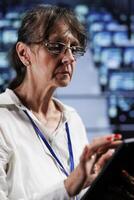 Seasoned wireman preparing cloud computing business recovery plan, monitoring data center energy consumption across parts, making sure sensors are in ideal condition, doing annual disk checks photo