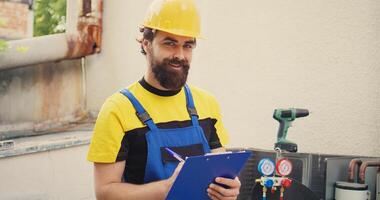 Expert technician doing inspection of freon levels and necessary repairs to prevent major breakdowns. Seasoned mechanic troubleshooting hvac system, writing findings on clipboard photo