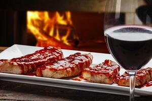 Roasted pork steak with barbecue sauce, glass of red wine photo