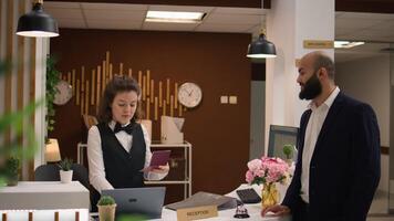 White collar worker gives id papers in lobby, preparing for registration after long business flight. Front desk employee reviewing passport credentials at reception, great service. photo