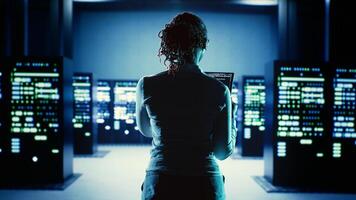 Skillful employee running code on tablet, troubleshooting and upgrading high tech workspace equipment designed to accommodate server units, networking systems and storage arrays photo