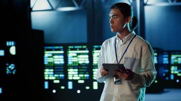 Qualified engineer strolling through data center server rows providing processing resources for different workloads. Proficient expert monitoring supercomputers tasked with solving complex operations photo