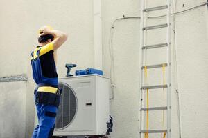 Certified engineer contracted to repair external air conditioner starting work shift. Expert technician wearing protective gear preparing to fix broken outdoor hvac system photo